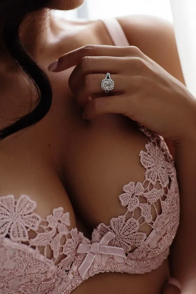 Fotografie boudoir de mireasă – detaliu bustieră roz dantelată și inel de logodnă