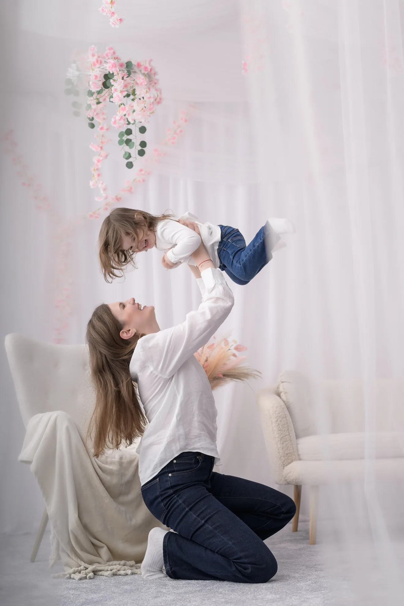 Mama si fiica jucandu-se sub tavan decorat cu flori roz, sedinta foto familie bucuresti dinamica