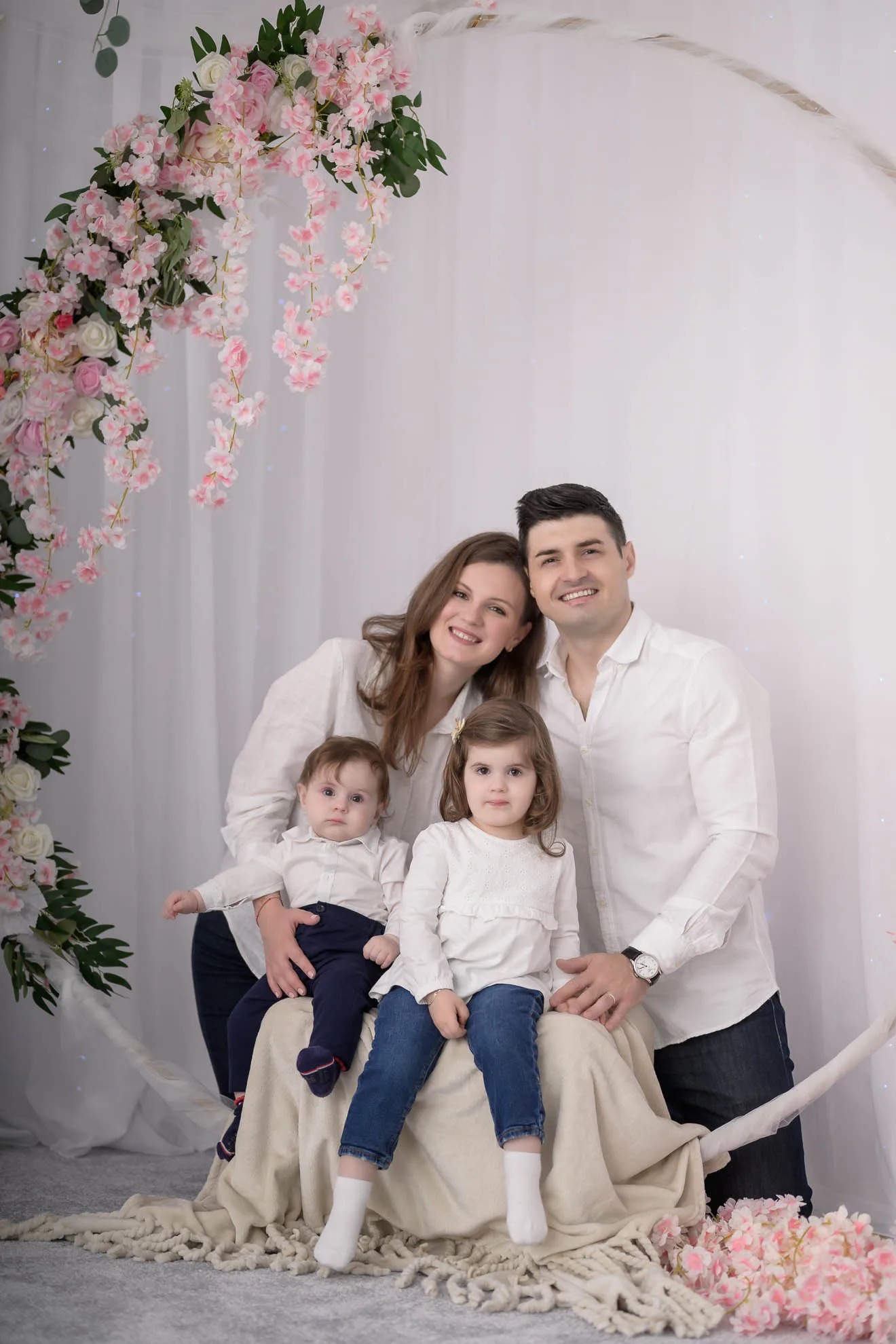 Parinti si copii pozand sub arcada de flori roz, sedinta foto familie bucuresti eleganta