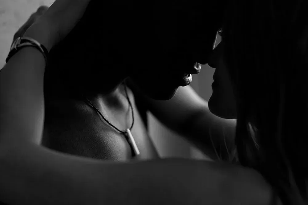 Poză intimă cuplu boudoir – detaliu romantic în lumină slabă