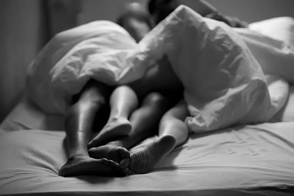 Ședință foto cuplu – picioare împreunate sub cearceaf, moment romantic