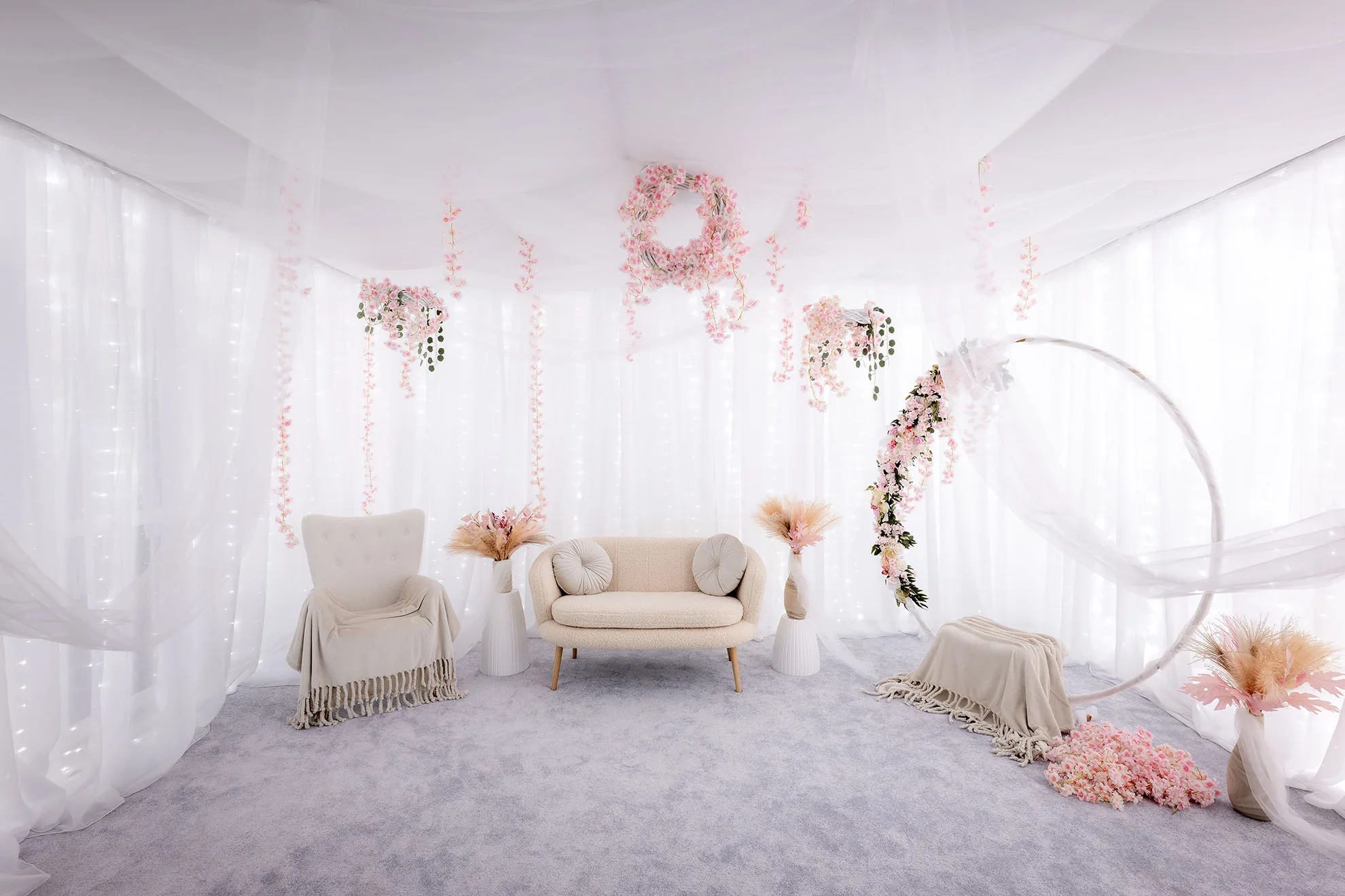Studio foto maternitate Bucuresti, decor alb boho cu flori roz, lumini calde si atmosfera eleganta