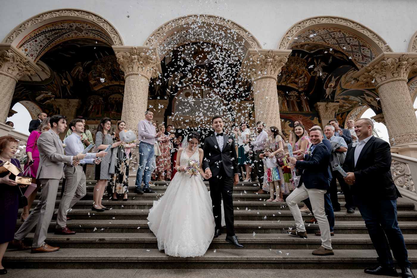 Miri iesind din biserica sub confetti – fotografie de nunta cu arhitectura eleganta